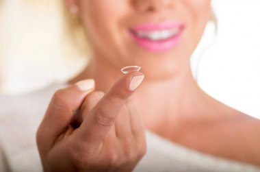Kontakt lens üstünde parmak beyaz arka plan., görme ve eyecare kavramı yüzünde önünde tutan genç kadın