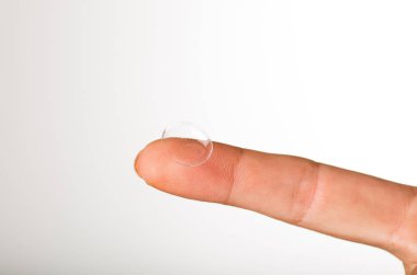 gri arka plan üzerinde parmak Kontakt lens