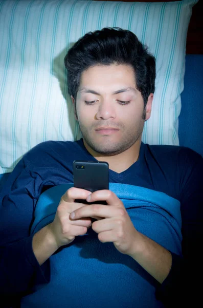 Les hommes toxicomanes des médias sociaux sur le lit ne dorment pas parce que jouer téléphone intelligent, ci-dessus vue — Photo