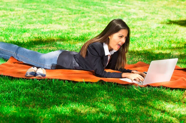 Chica joven y feliz con ordenador portátil en el parque — Foto de Stock