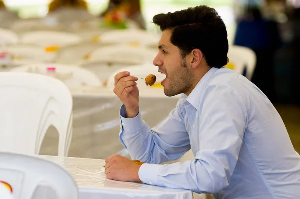 Handsome young businessman eating a homemade fritters with sugar and its ingredients — Stock Photo, Image