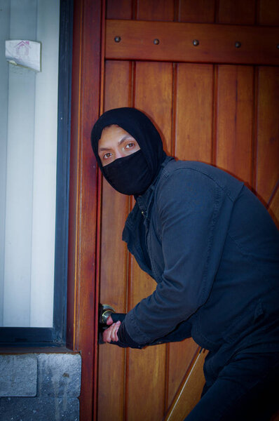 Грабитель в маске пытается войти в дом
