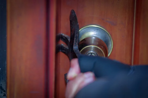 Primo piano di un ladro con piede di porco che tenta di rompere la porta per entrare in casa — Foto Stock