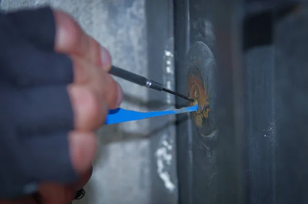 Fechar de um ladrão segurando Lock-picker para abrir uma porta de casa — Fotografia de Stock