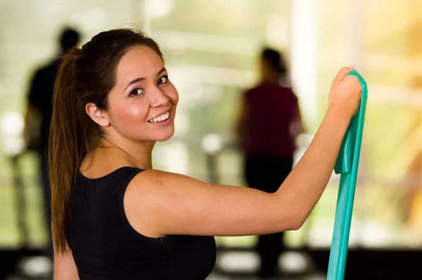 Girl using a resistance band in her exercise routine. Woman fitness elastic excercises — Stock Photo, Image