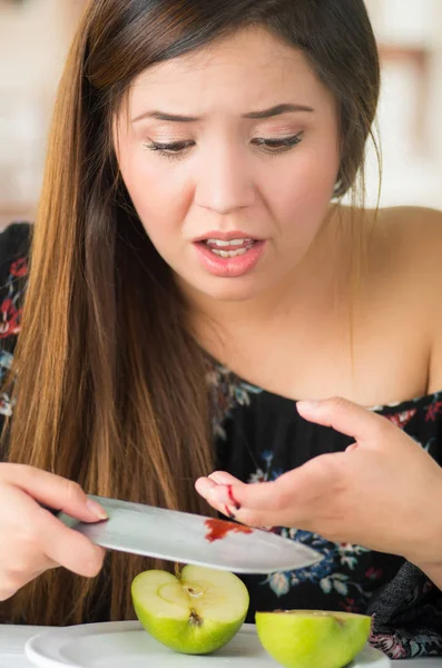 Una bella donna si è ferita le dita con un coltello tagliando una mela — Foto Stock