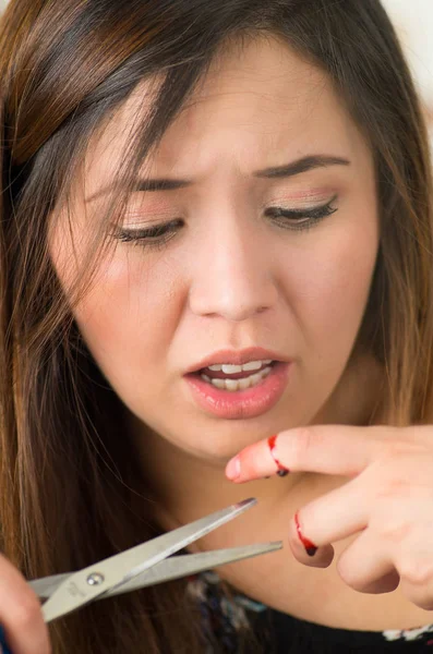 Shocked young girl suffered a cut finger with scissors — Stock Photo, Image