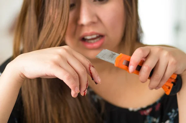 Hermosa joven se lesionó el dedo con un cortador naranja — Foto de Stock