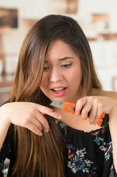 Belle jeune femme blessée au doigt avec un coupe-orange — Photo