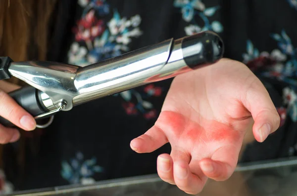Close-up van een vrouw verbrand haar hand met haar krullend haar Strijkservice — Stockfoto