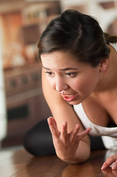 Beautiful young woman bleeding from her nose, on wooden floor — Stock Photo, Image