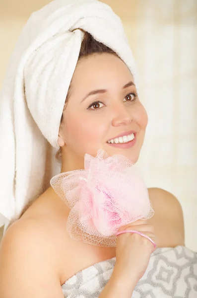 Hermosa chica joven y fresca con toalla sosteniendo esponja de cuerpo de esponja rosa — Foto de Stock