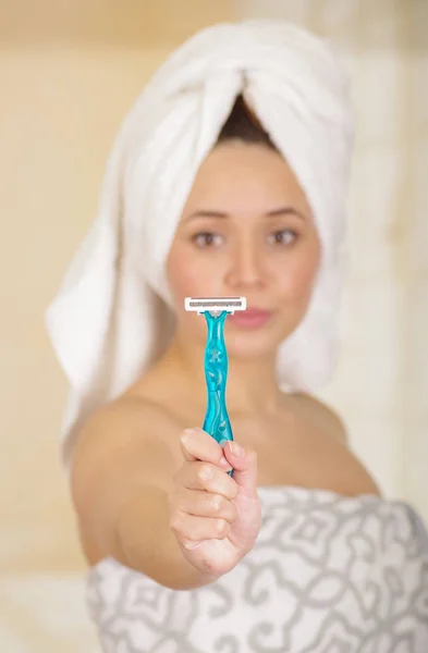 Beautiful fresh young girl with after shower towel holding blue razor — Stock Photo, Image