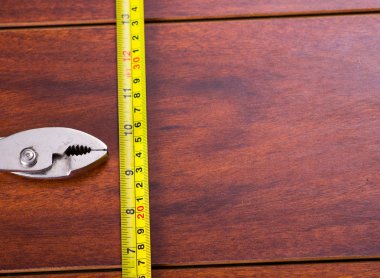 Pense ve şerit metre ahşap arka plan üzerinde