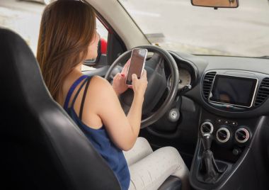 Arabada tek başına sürücüler cep telefonunu, kullanarak güzel gülümseyen genç bayan