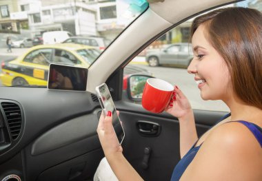 Bir fincan kahve ya da çay içme ve onu tutarak diğer el bir cep telefonu, araba kendi kendine kullanıyor güzel bir genç kadının yakın çekim