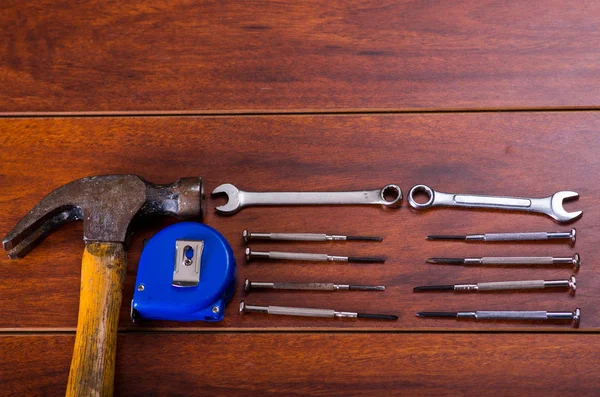 Строительные инструменты, плоские ключи, молоток, лента мера на деревянном фоне — стоковое фото