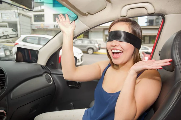 Close up of a beautiful smiling young lady with a black rag covered her eyes, while the car drives by itself — Stock Photo, Image