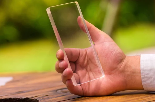 El hombre sostiene el teléfono inteligente transparente futurista en su mano —  Fotos de Stock