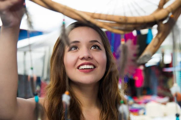 Mulher sorridente bonita olhando um cardreams borrado na roupa tradicional andina e artesanato, fundo do mercado — Fotografia de Stock