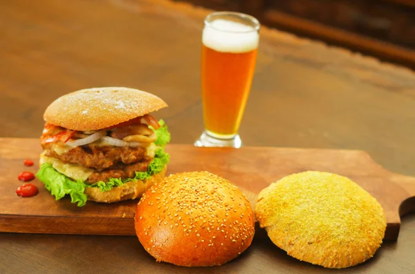 Deliciosa hamburguesa completa con dos piezas de pan al lado de la hamburguesa sobre tabla de madera —  Fotos de Stock