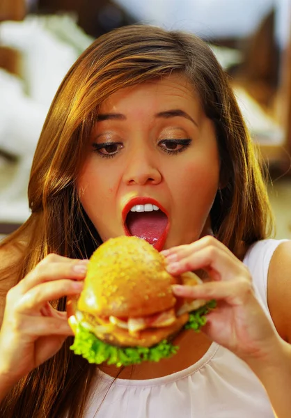 Primer plano de una mujer de belleza en la cafetería con la boca abierta lista para comer una deliciosa hamburguesa —  Fotos de Stock