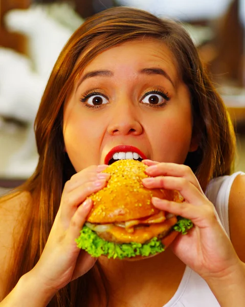 Primer plano de una mujer de belleza en el café comiendo una deliciosa hamburguesa —  Fotos de Stock