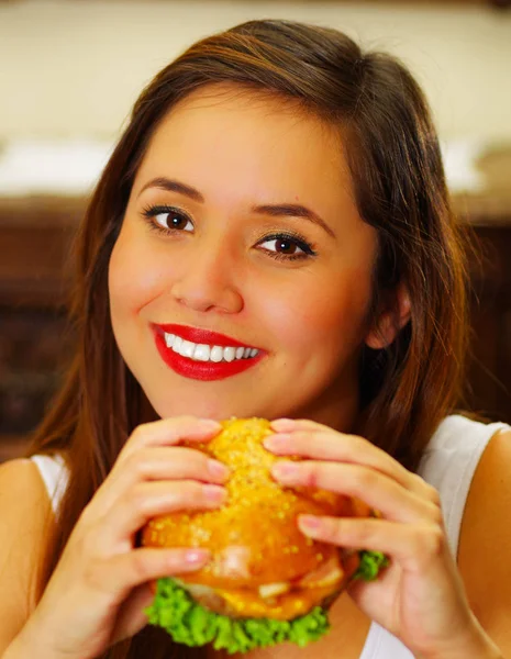 Gros plan d'une femme de beauté dans un café tenant un délicieux hamburger — Photo