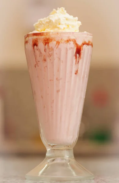 Läcker strawberry milkshake med sirap och grädde på toppen — Stockfoto