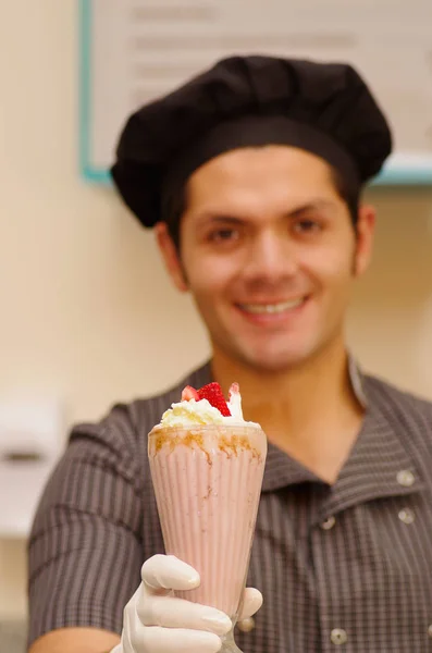 Knappe man met een chef hoed poiting in van hem een milkshake — Stockfoto