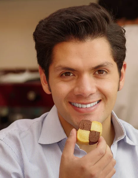 Närbild av en ung affärsman äta cookie — Stockfoto