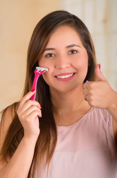 Acercamiento de una hermosa joven con una afeitadora en la cara con un golpe hasta — Foto de Stock