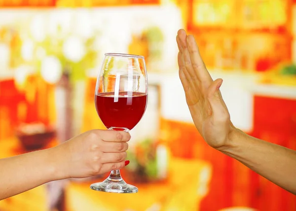 Крупный план руки, держащей стакан виски, и мужской руки, отказывающейся от него, на заднем плане бара — стоковое фото