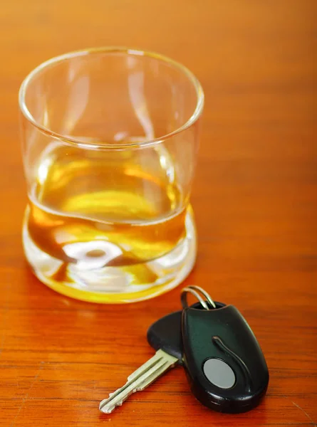 Närbild på ett glas whiskey med bilnycklarna på träbord — Stockfoto