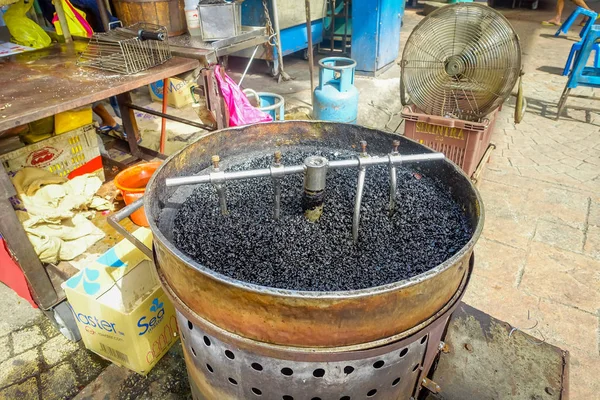 Panela com seixos quentes para assar castanhas, comida de rua em Chinatown, Kuala Lumpur — Fotografia de Stock