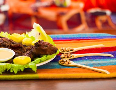 Geleneksel Ekvador yemek, ızgara eskiden şiling şimdi domuz yeşil plaka, patates, tostados ve limon tarafında, yukarıda da görüleceği üzerine yayılmış
