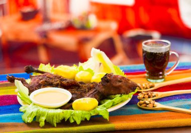 Geleneksel Ekvador yemek, ızgara eskiden şiling şimdi domuz yeşil plaka, patates, tostados ve limon tarafında, yukarıda da görüleceği üzerine yayılmış