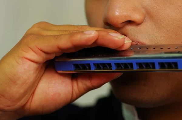 Jeune homme autochtone jouant de l'harmonica — Photo