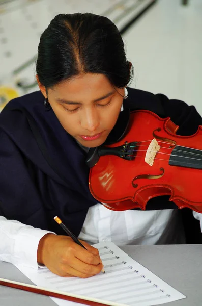 Indigenous young man writing notes to music with violin, concept of composition — Stock Photo, Image