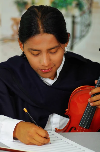 Indigenous young man writing notes to music with violin, concept of composition — Stock Photo, Image