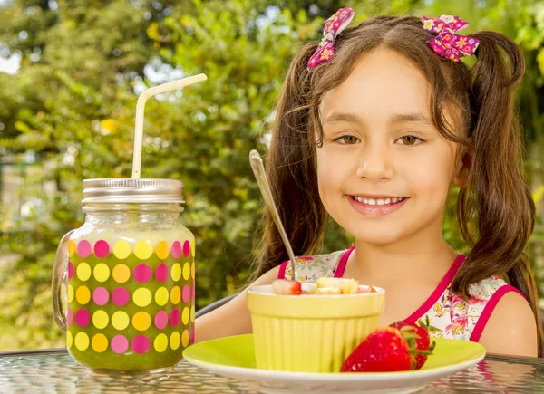 Close up of a beautiful young girl, preparing to eat a healthy fruit salad and a healthy drink in a garden background — Stock Photo, Image