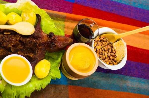 Traditional ecuadorian dish, grilled guinea pig spread out onto green plate, potatoes, tostados and lemons on the side, seen from above — Stock Photo, Image