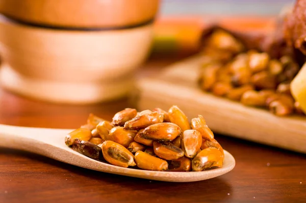 Cuillères en bois avec des grains de maïs grillés, connu sous le nom tostado en Amérique du Sud , — Photo