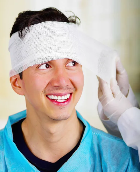 Portret młodego mężczyzny z traumą w jego głowie i elastyczne bandażach wokół jego głowy — Zdjęcie stockowe