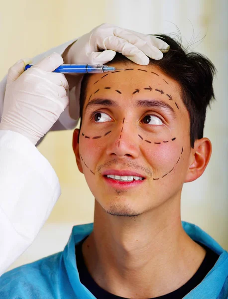 Крупный план красивого молодого человека, получающего косметические уколы для лица, доктора, держащие шприц в перчатке — стоковое фото