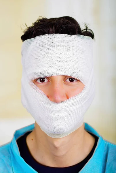 Potret seorang pemuda dengan trauma di kepalanya dan perban elastis sekitar kepalanya — Stok Foto