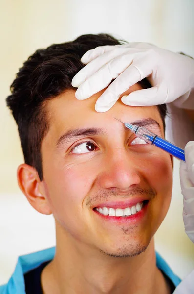 Csinos, fiatal férfi, fogadó kozmetikai arckezelés injekciók, orvosok kezét kesztyű gazdaság fecskendővel — Stock Fotó