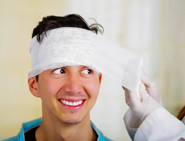 Doctor tocando la cabeza de un hombre con trauma en la cabeza y vendado elástico alrededor de la cabeza — Foto de Stock