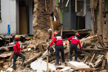 Quito, Ekvator - 09 Aralık 2016: Firemans hasar alan ve yıkım, yangından Inferno binalarda sonra enkaz Temizleme, kimliği belirsiz bir gurup