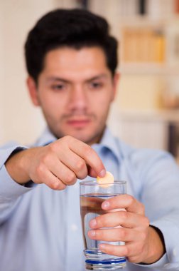 Yakışıklı adam düşüyor efervesan tablet bardak su